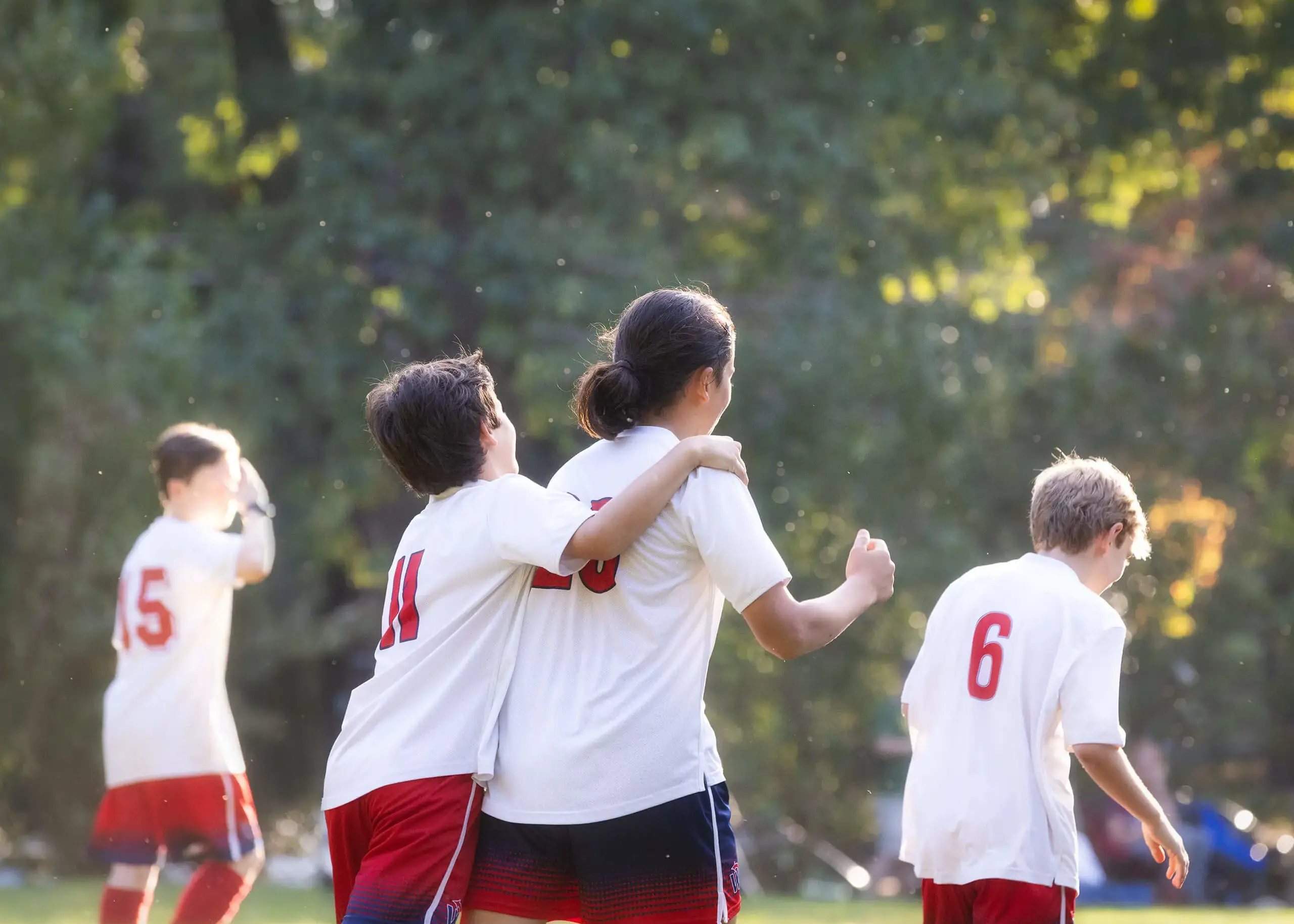 four soccer players in sunlight