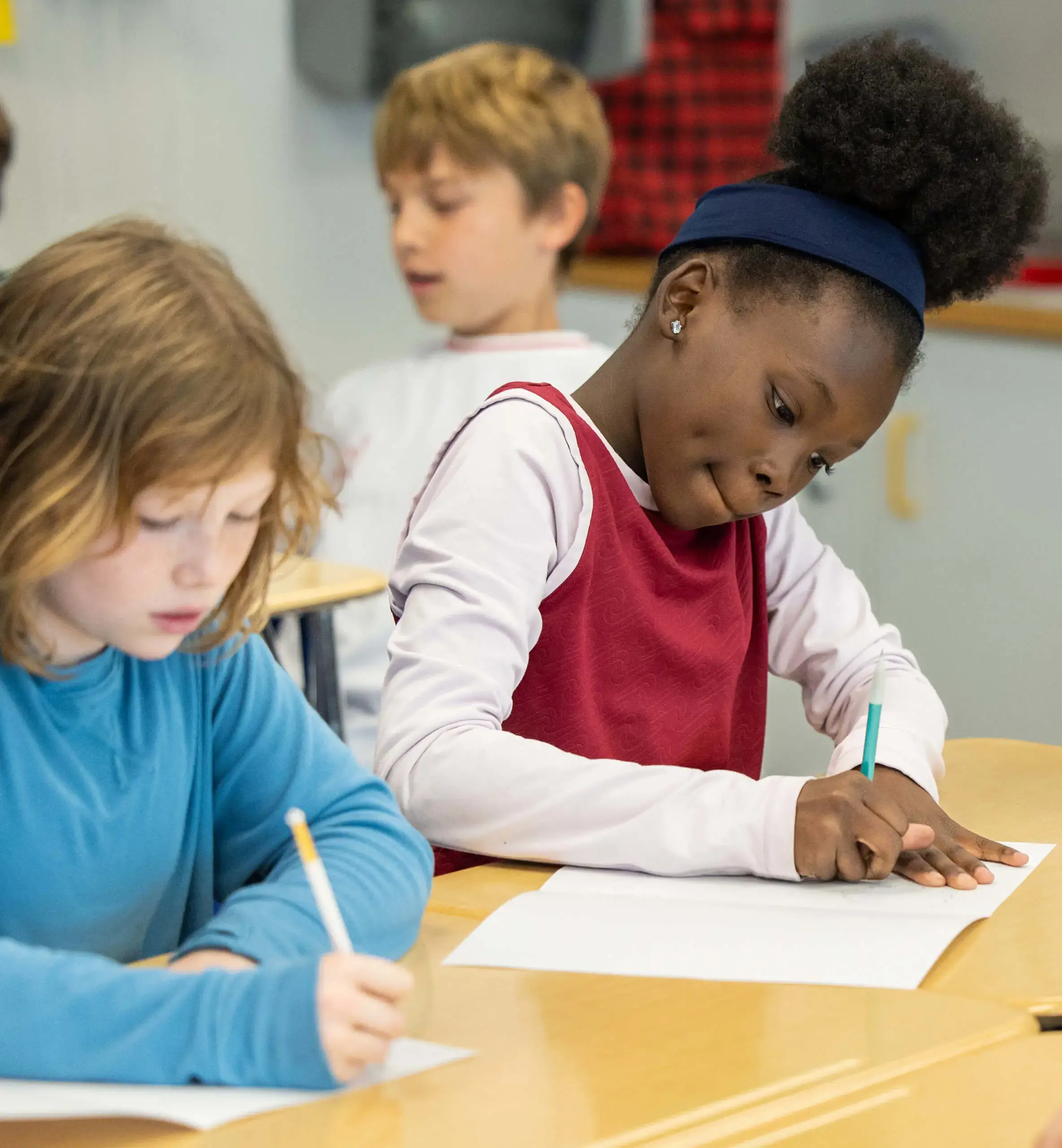 two girls writing with pencils