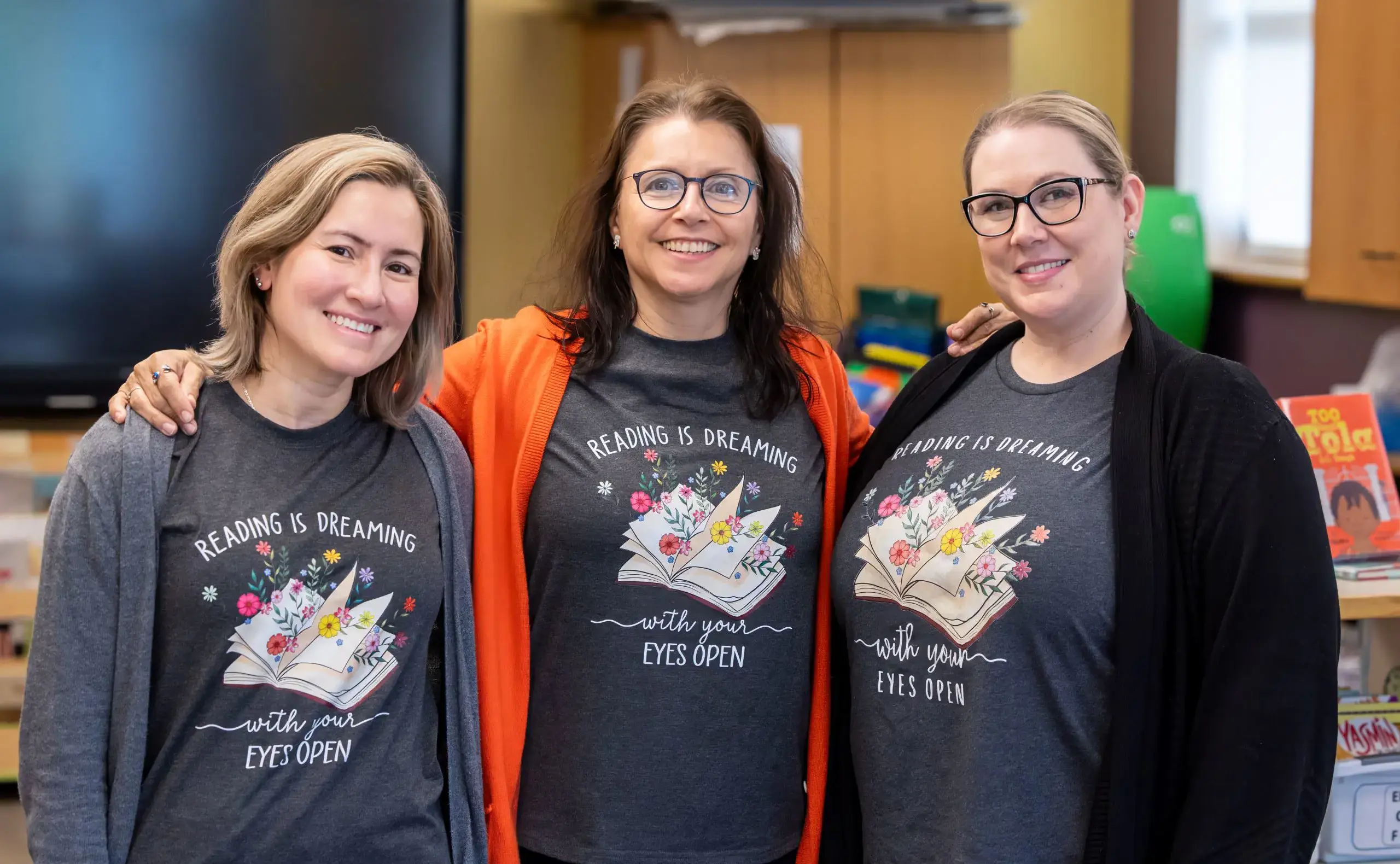 Three librarians arm in arm