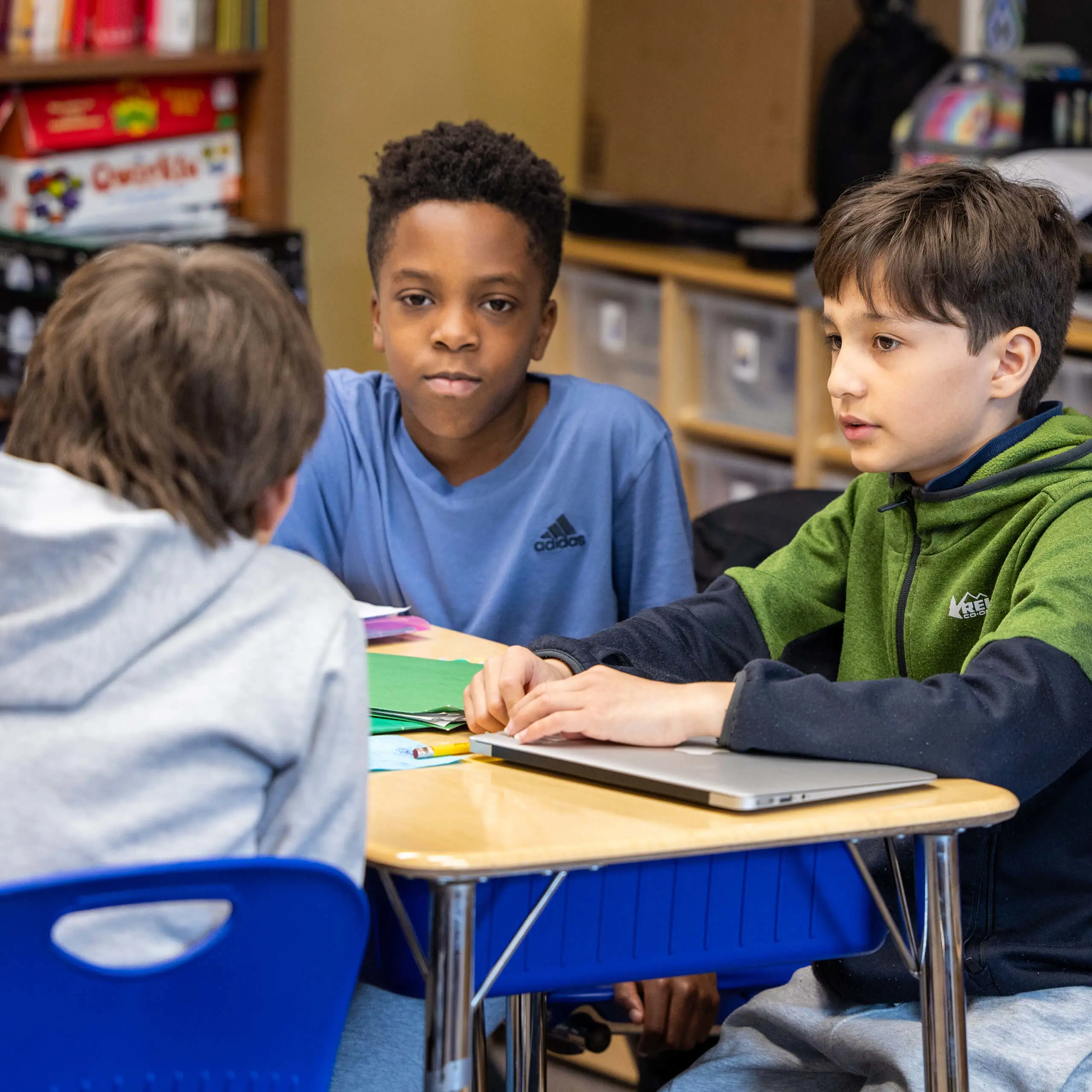 three boys in a classroom at desks