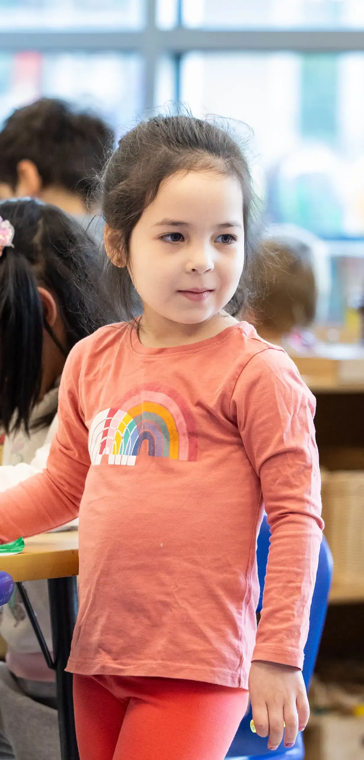 little girl in a rainbow shirt