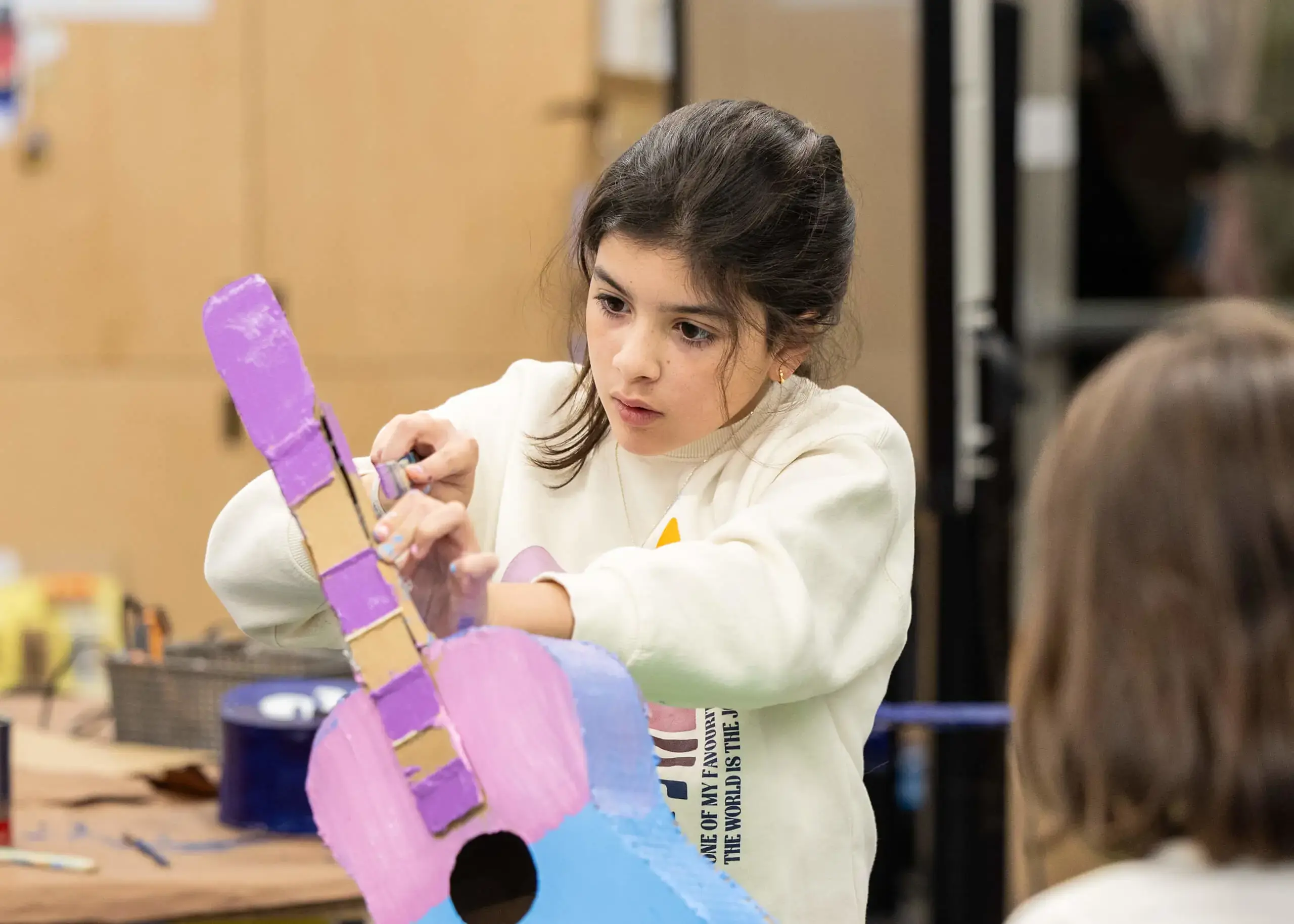 girl making a cardboard guitar