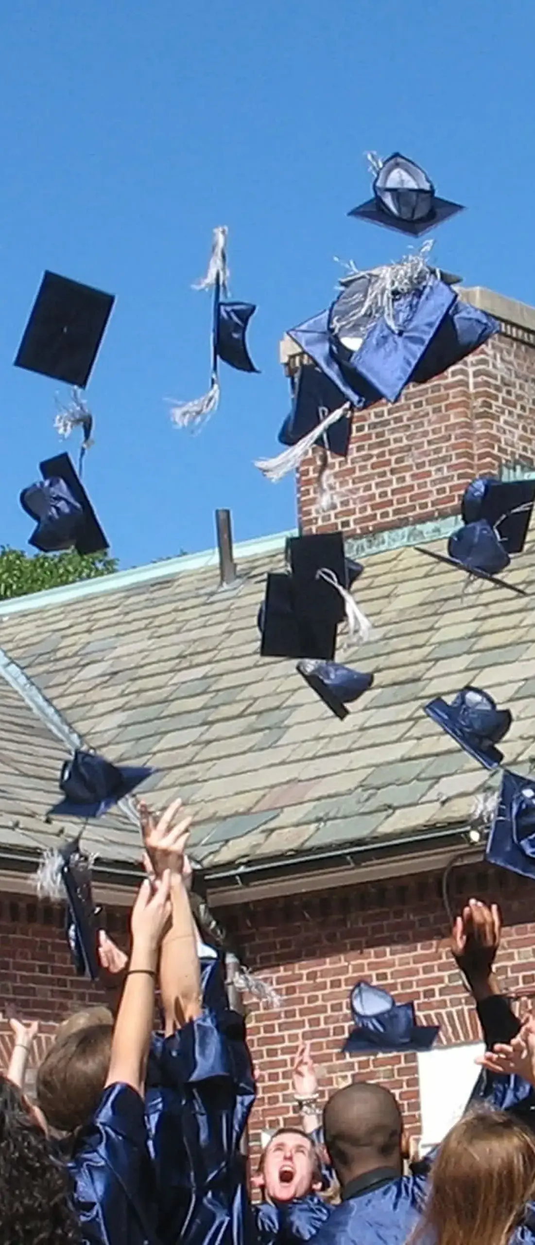 graduates celebrating by throwing caps in the air