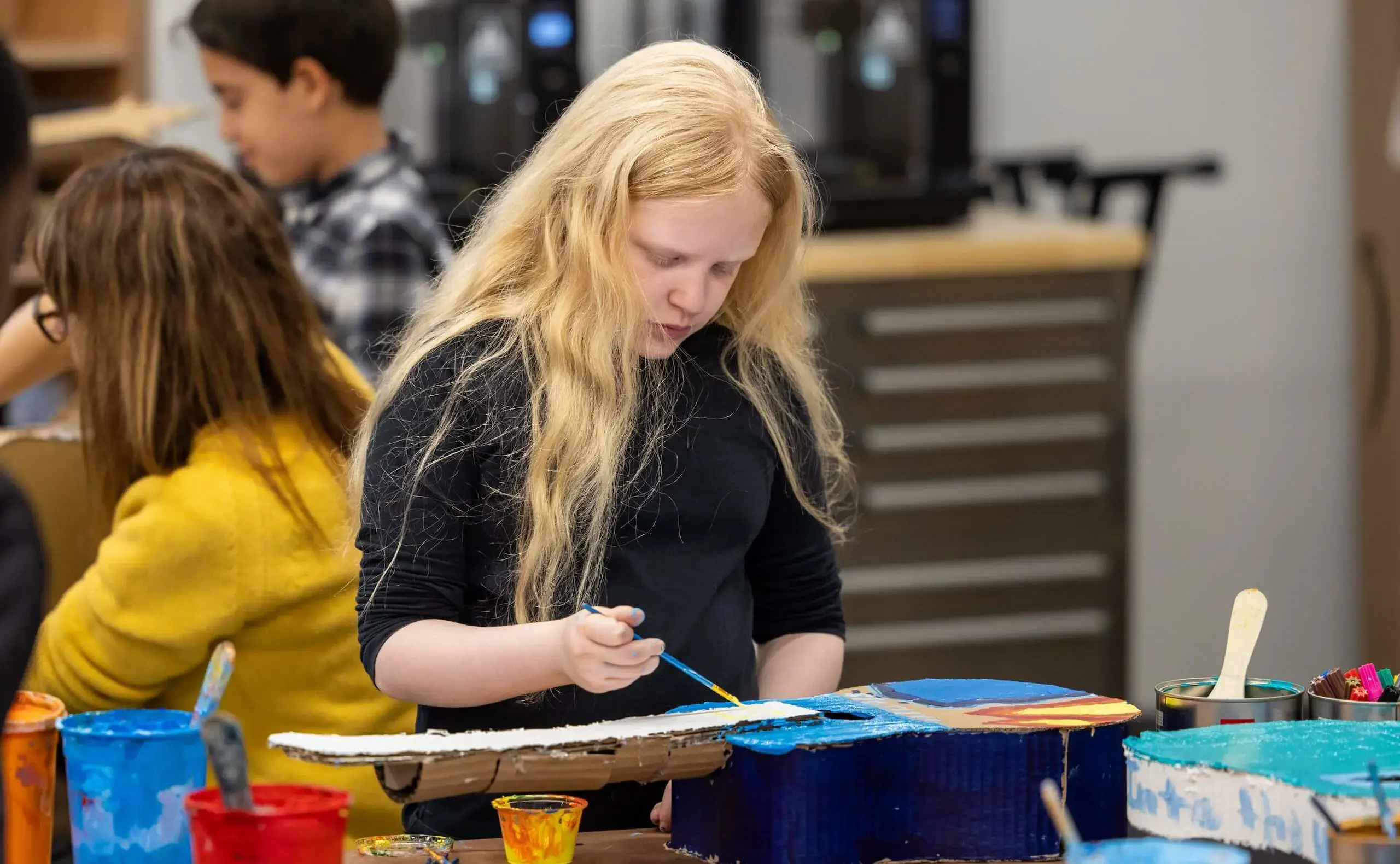 Student painting guitar dark blue